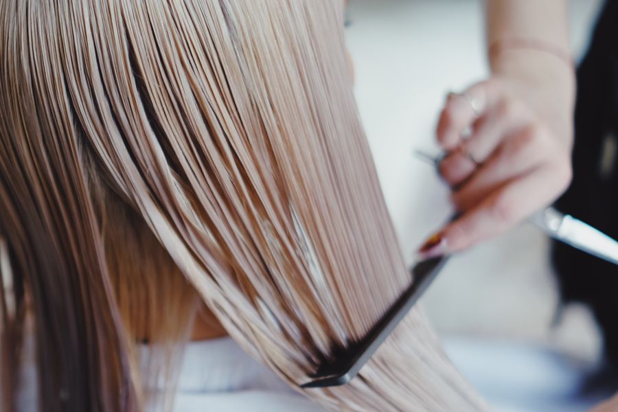 Close-up of freshly coloured blonde hair being combed through